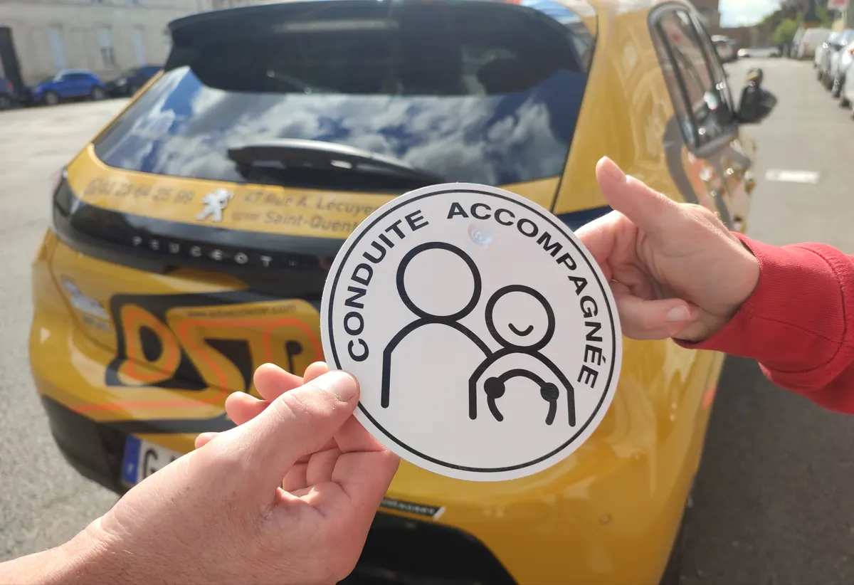 Remise du disque « Conduite accompagnée » devant une voiture OSR