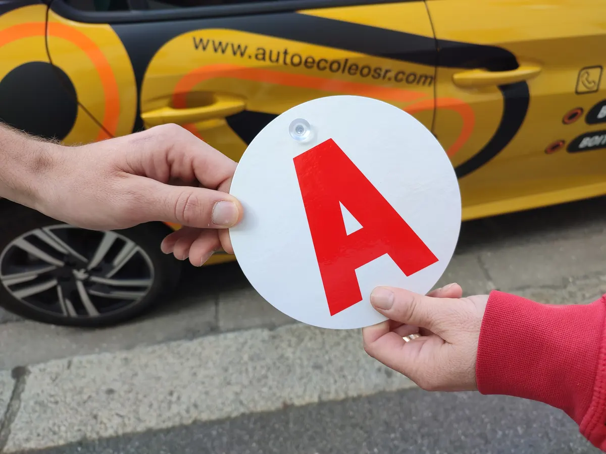 Remise du disque « A » de jeune conducteur devant une voiture de l'Auto École OSR