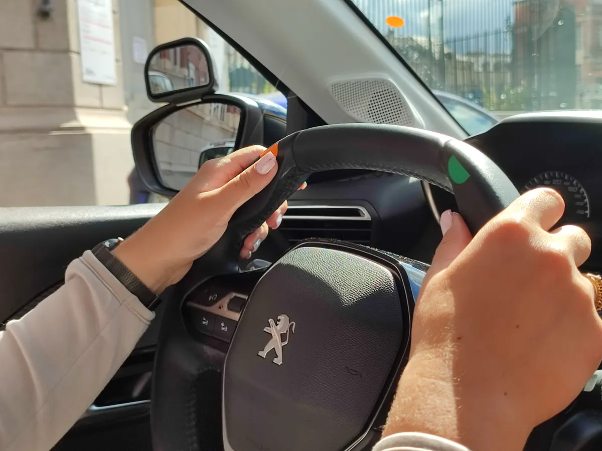 Mains sur le volant pendant une leçon de conduite en ville